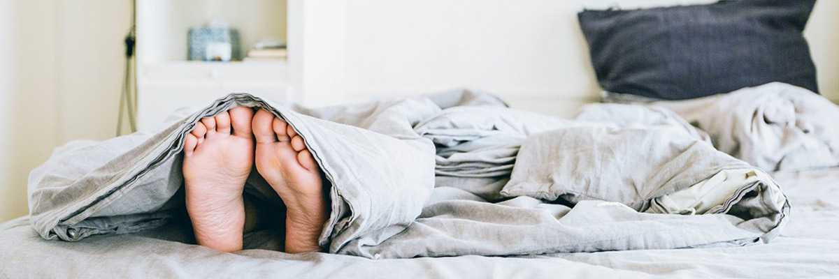 Man Sleeping in the Bed with uncover Feet