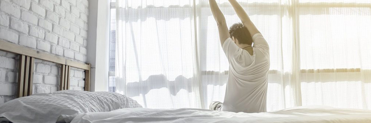 Man stretching in the Bed after Waking Up