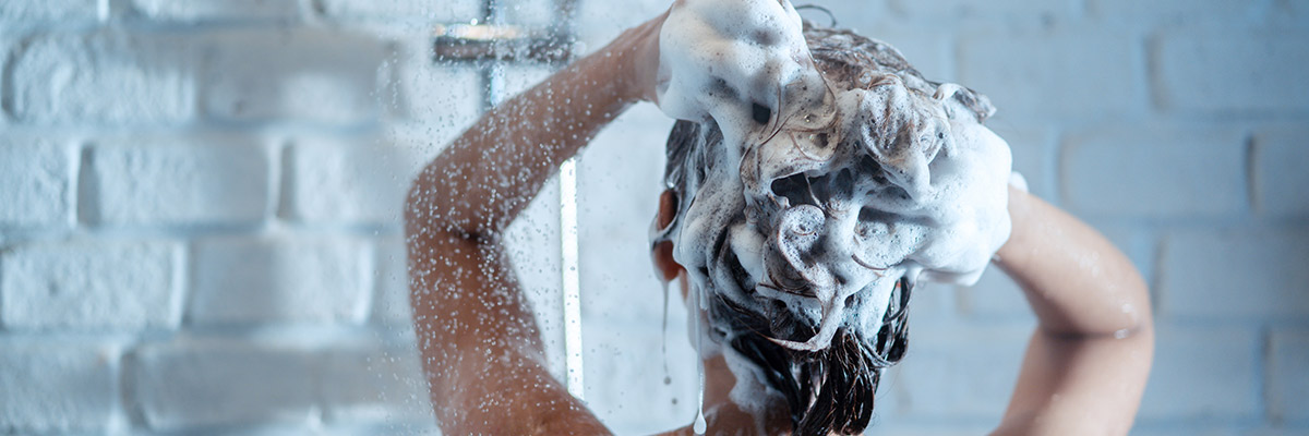 Woman Taking Shower and Washing Hair with Shampoo